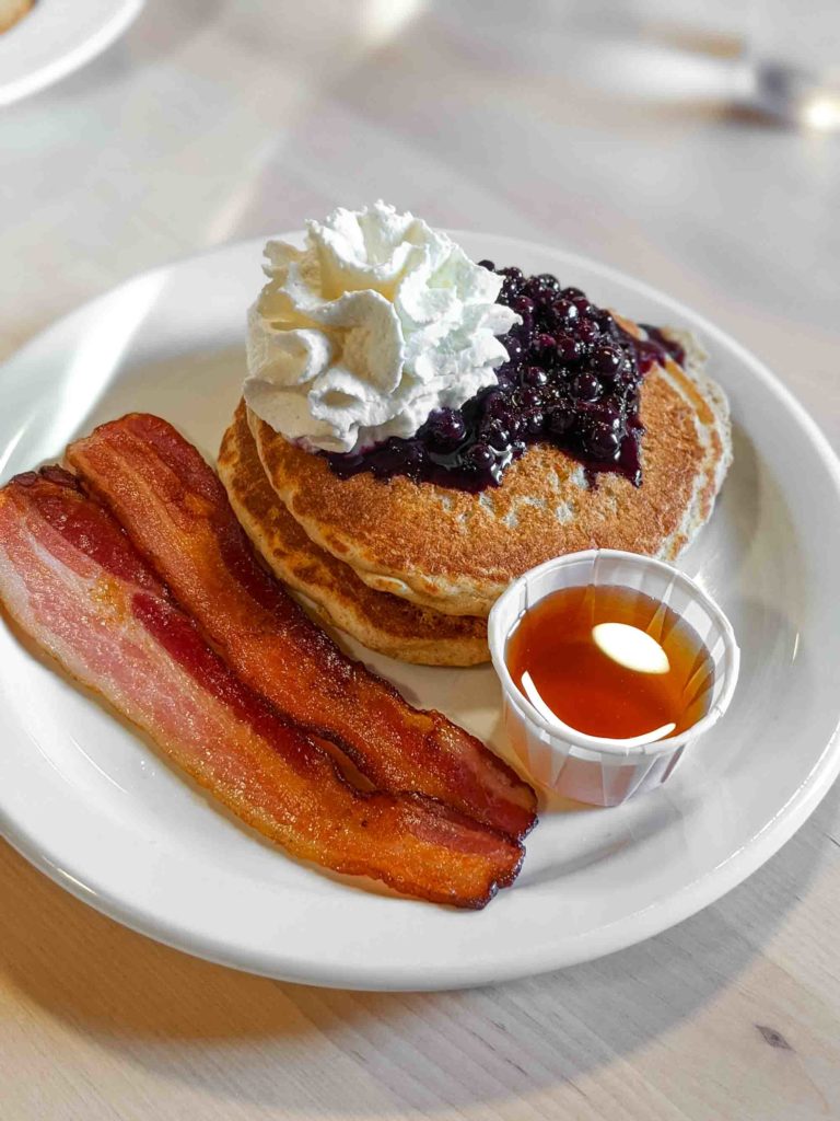 Pancakes with bacon and a side of maple syrup