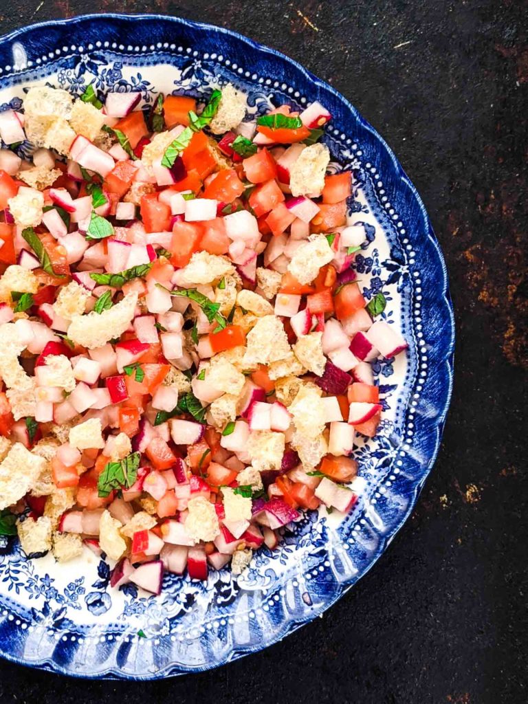 Chojin Guatemala radish salad in a blue decorative bowl on dark background