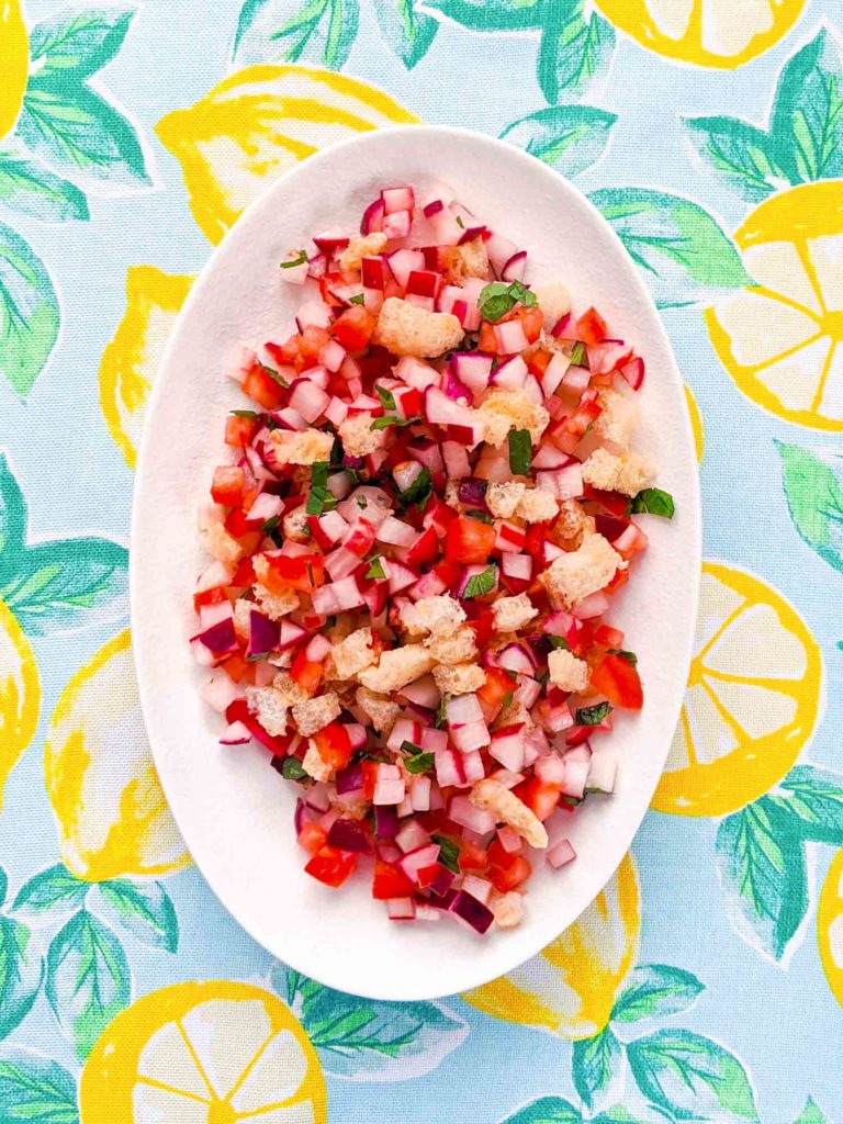 Guatemalan radish salad on a white plate and colourful tablecloth