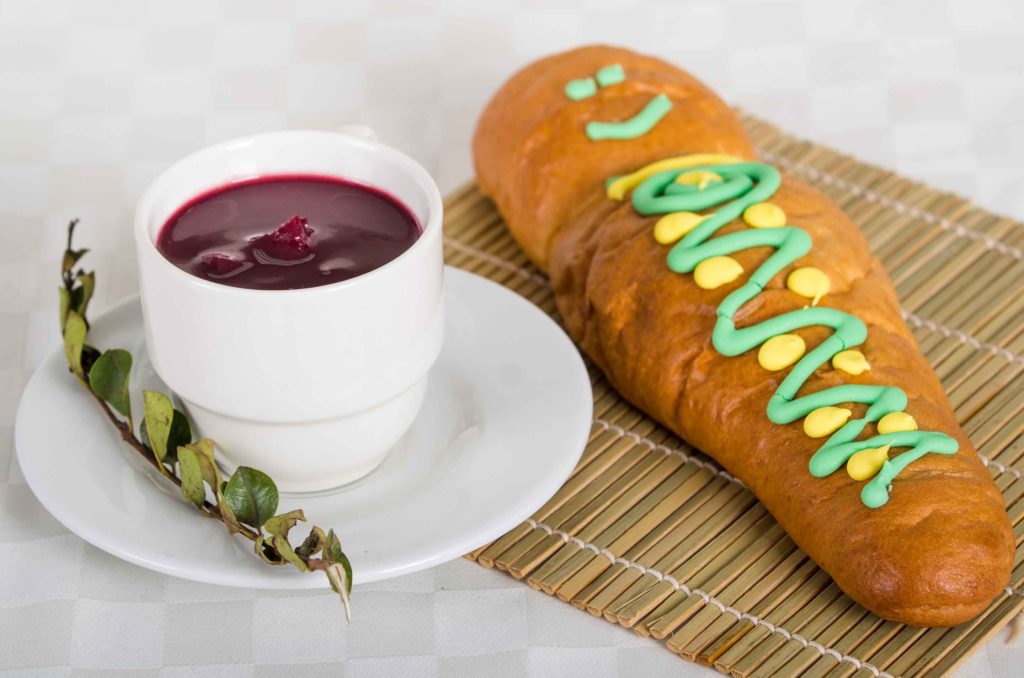 Traditional bread babies or guaguas de pan and colada morada drink, served on the Day of the Dead in Ecuador