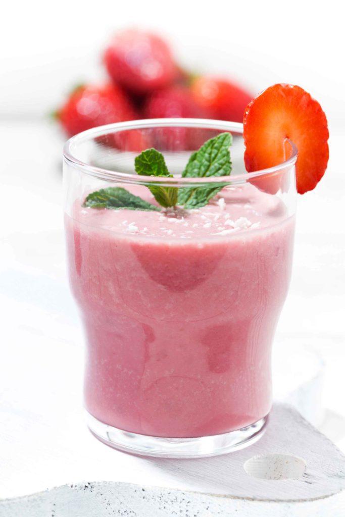 refreshing strawberry milkshake on white table, closeup