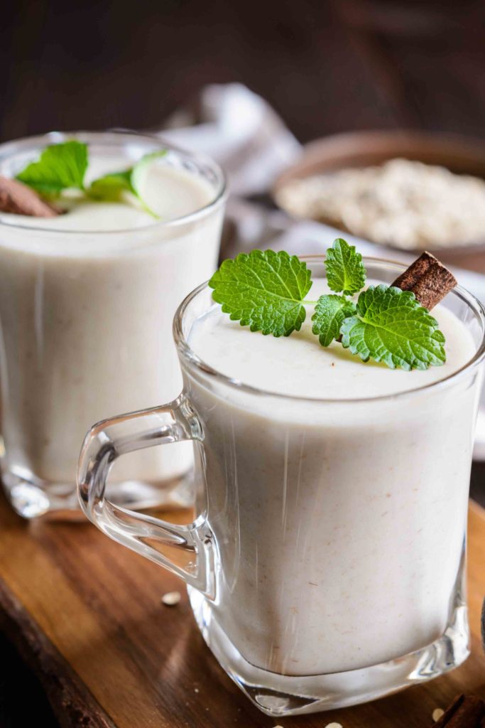 Guatemalan horchata garnished with lime and a cinnamon stick on a wooden table