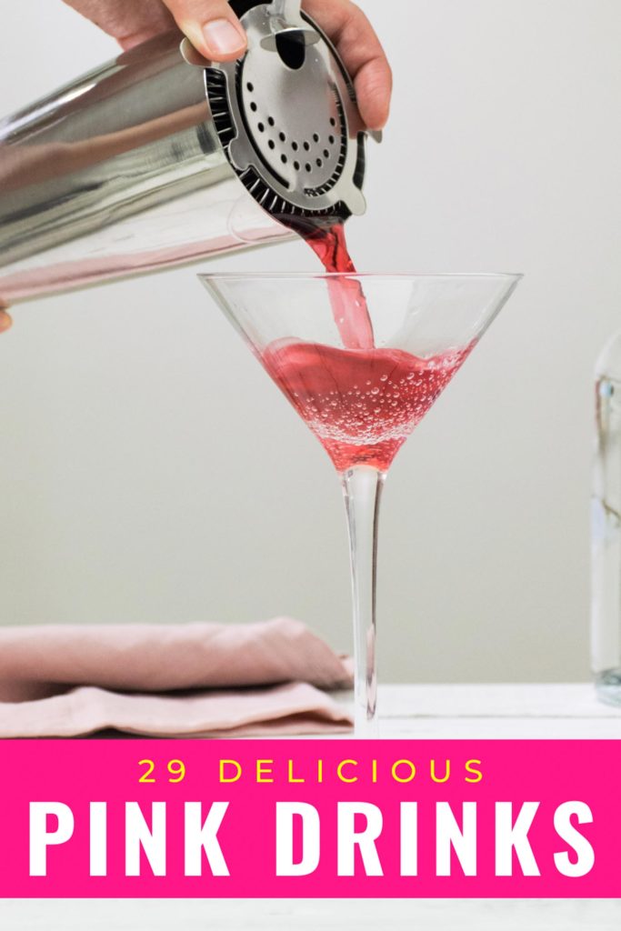 Person pouring pink drink into martini glass