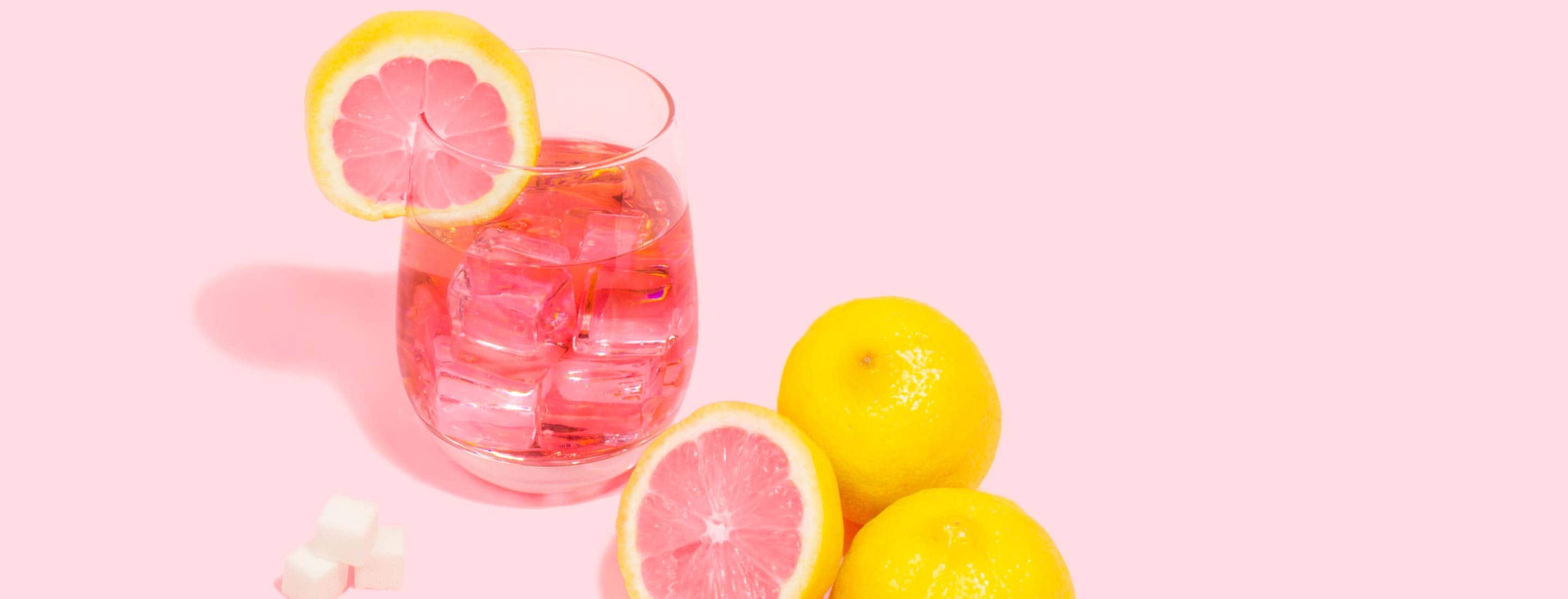 pink grapefruits alongside pink cocktail drink