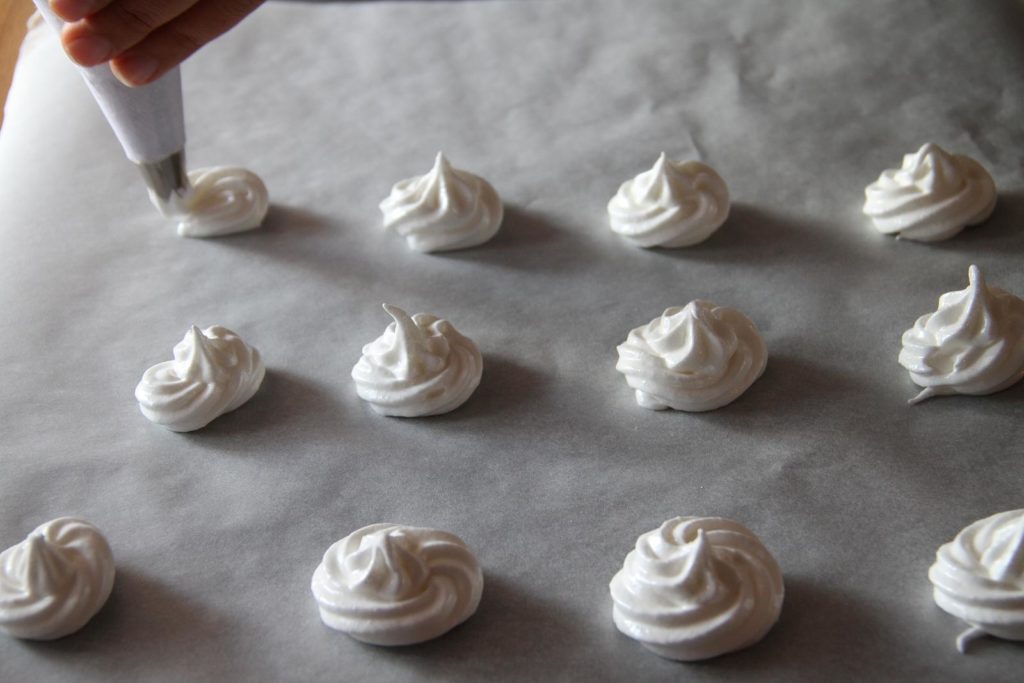 Rows of suspiros in Ecuador or meringues on a baking sheet.