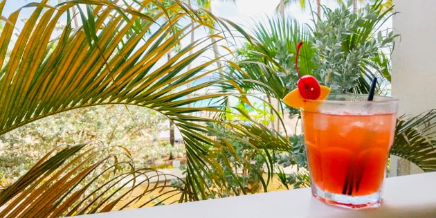 Rum punch on a table with palm trees in back in Barbados