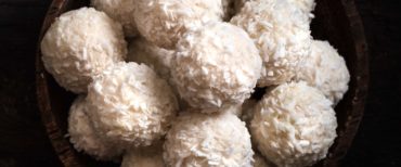 Sweet coconut pralines in wooden bowl,blank space