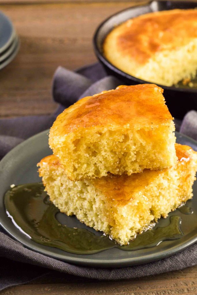 Costa Rican pan de maiz. Slice of sweet cornbread with honey on the plate.