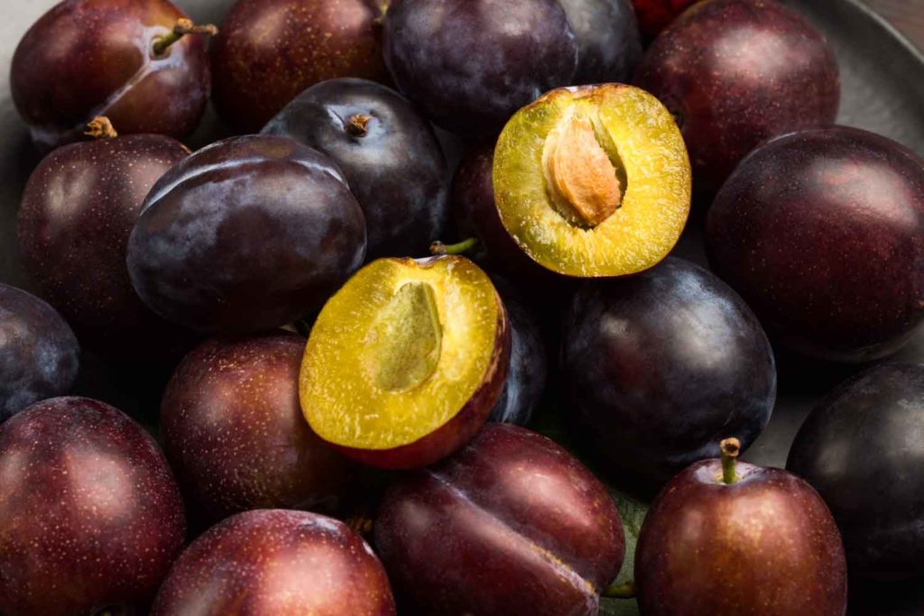 Colombian fruits corozo. Cut plum. Half plum with pit. Close up. Fruits. Top view