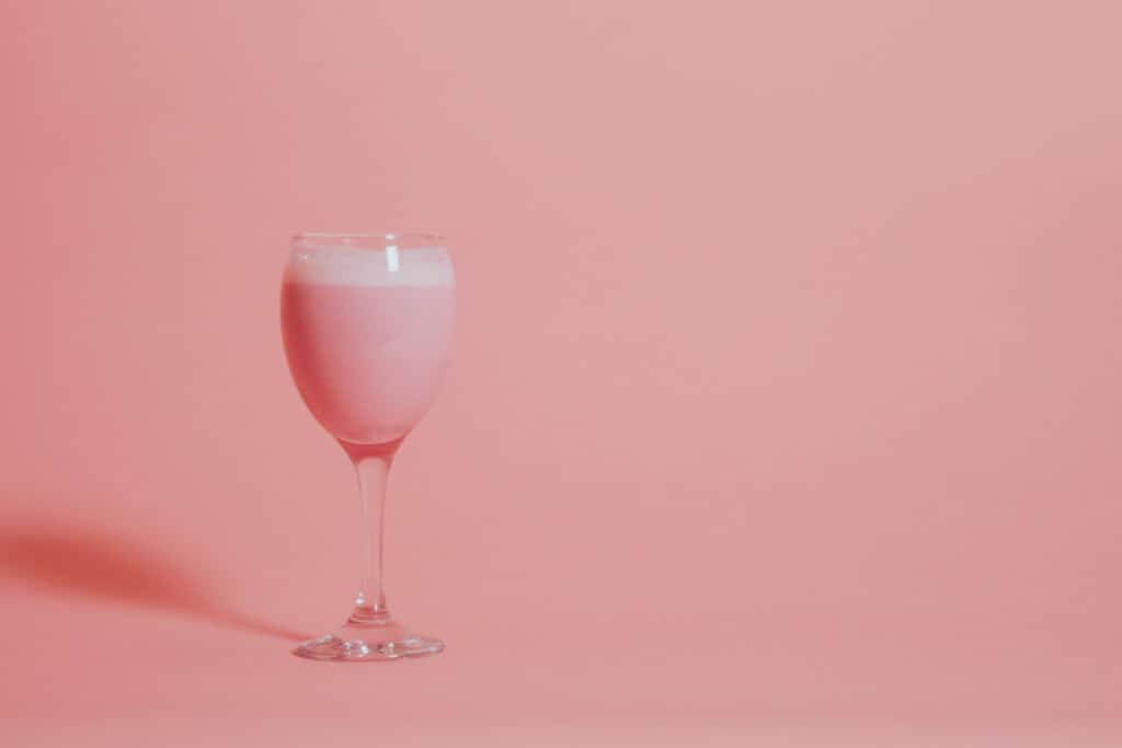 Frutillada Peruvian drink in a wine glass on pink background