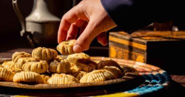 Jordanian dessert maamoul for a hand holding a piece