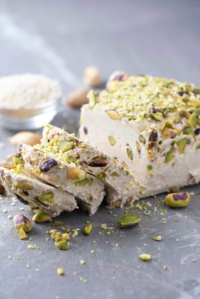 Jordanian desserts Sesame halva with pistachios on grey background. Top view. Copy space. Traditional middle eastern sweets. Jewish, turkish, arabic 