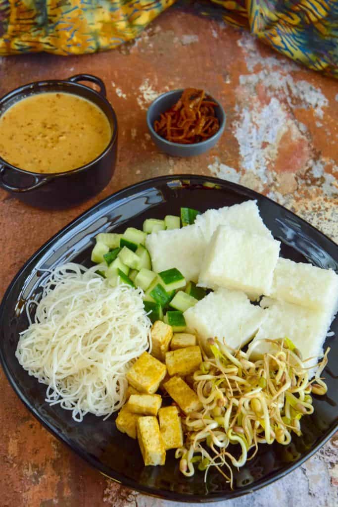 Vegetarian Indonesian food Ketoprak on a black plate and rustic background