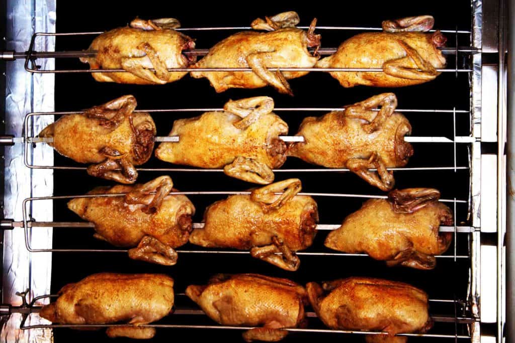 Rotisserie chickens on spit at restaurant