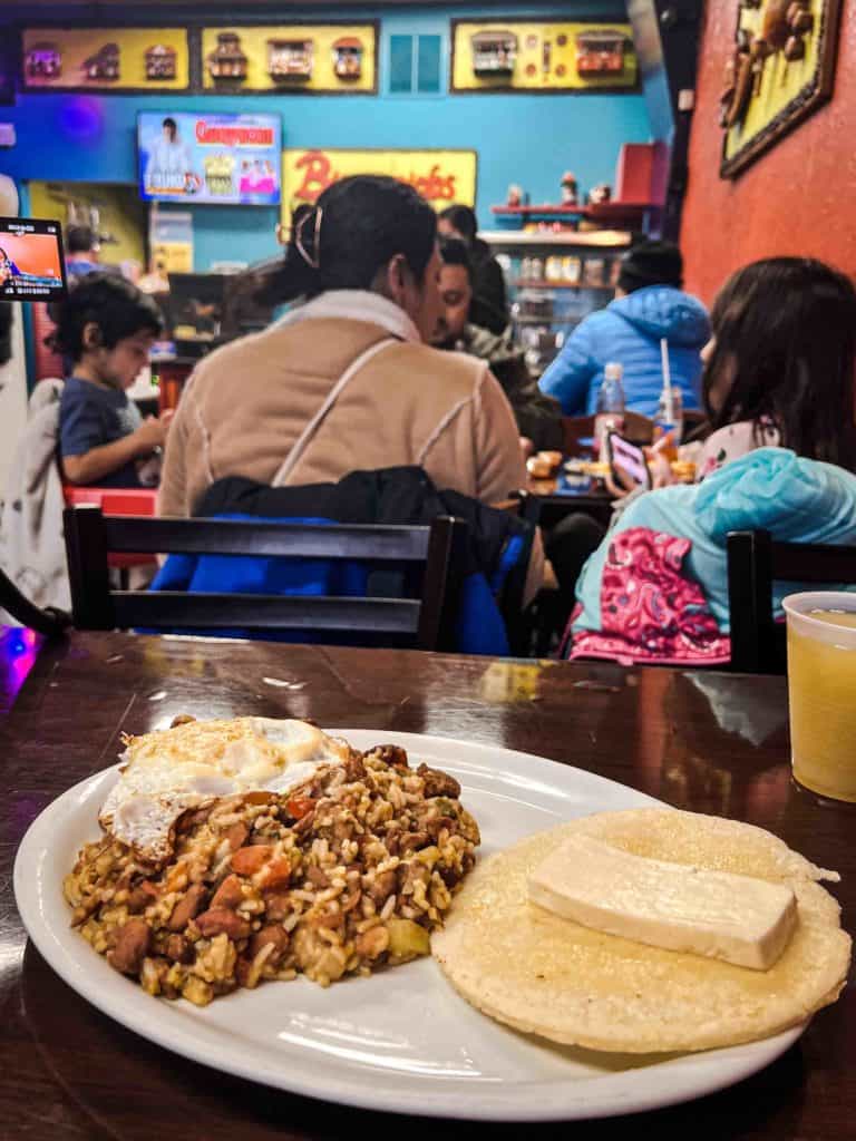 Calentado and arepa con queso on table in Colombian restaurant