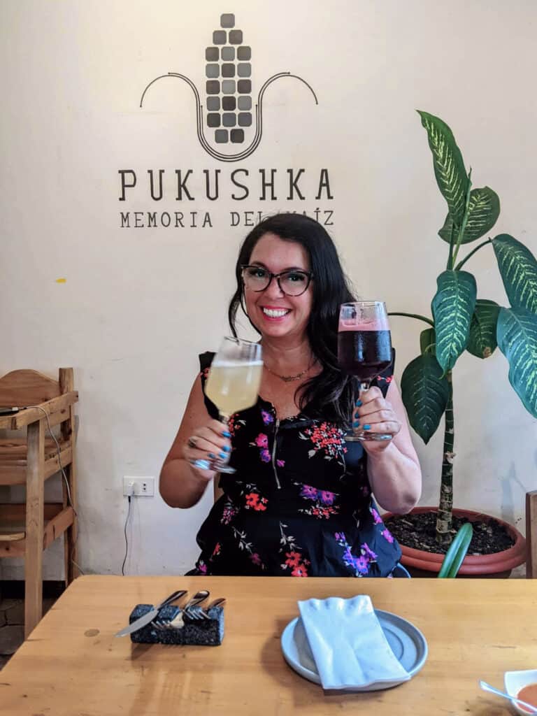Woman holding glasses of chicha de jora, Peruvian drinks