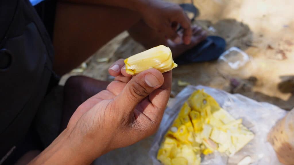 man holding piece of jackfruit in hand in Vietnam