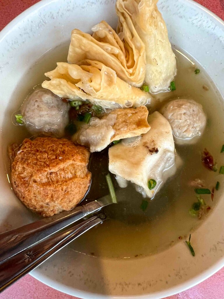 Bakso a meatball soup dish from Malang with tofu, fried wonton and fritter in a broth in a bowl