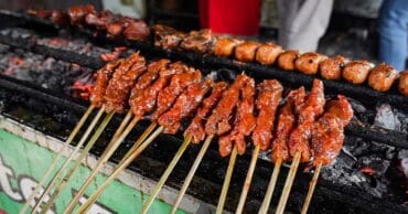 Indonesian street food chicken sate on a grill