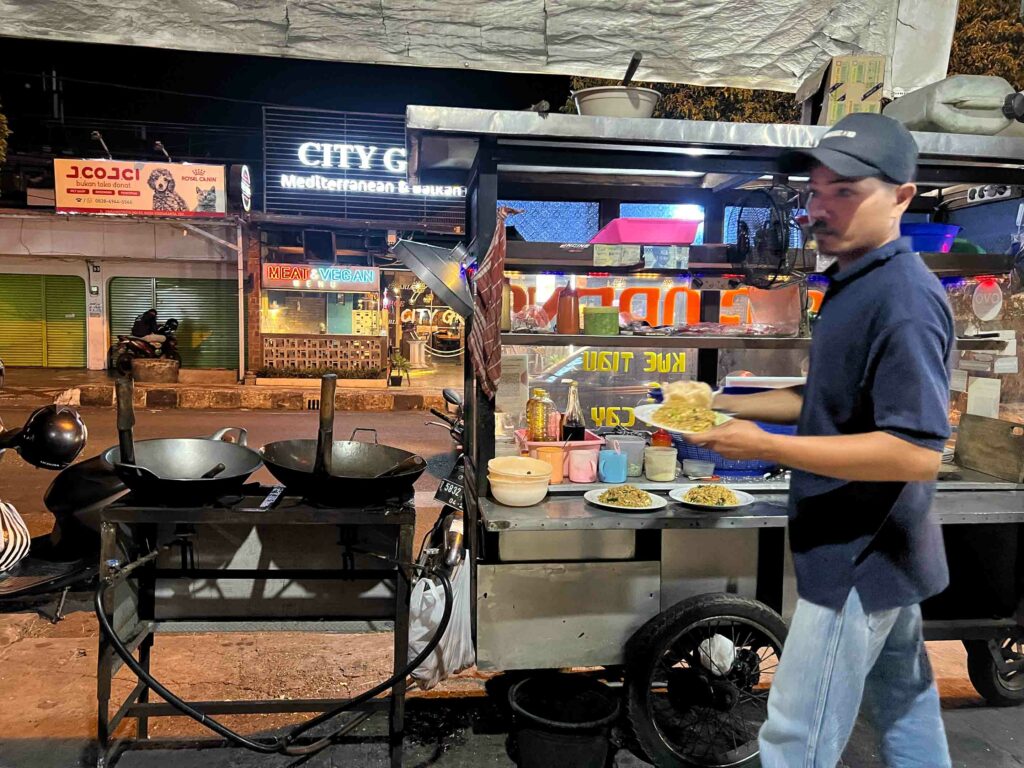 Nasi goreng vendor in Yogyakarta Indonesia serving customers