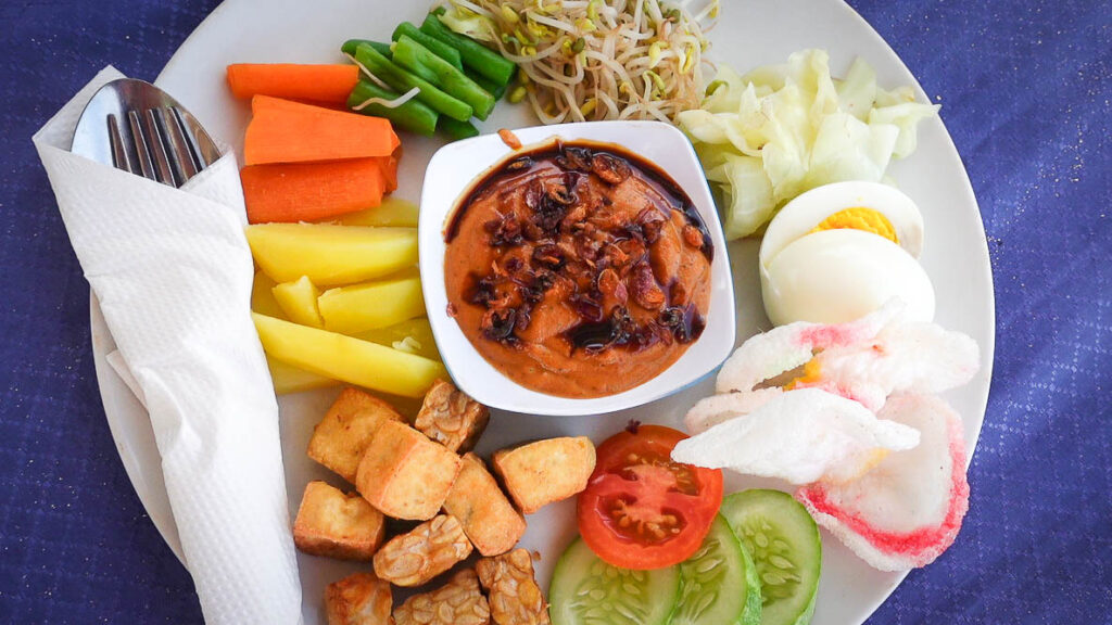 Nasi pecel from Indonesia a vegetable dish with tofu, tempeh, egg and peanut sauce