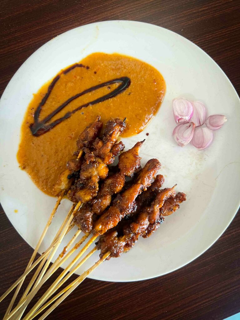 Grilled rabbit on a stick with a side of spicy peanut sauce in Malang Indonesia