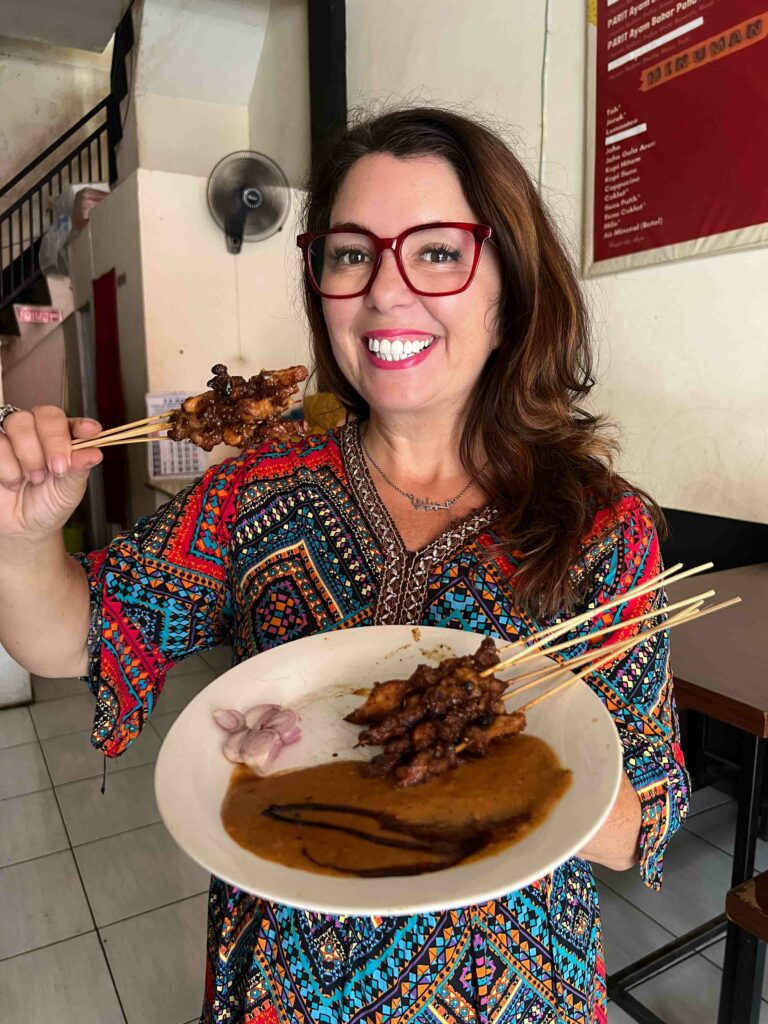 Ayngelina eating grilled rabbit on a stick in Malang Indonesia