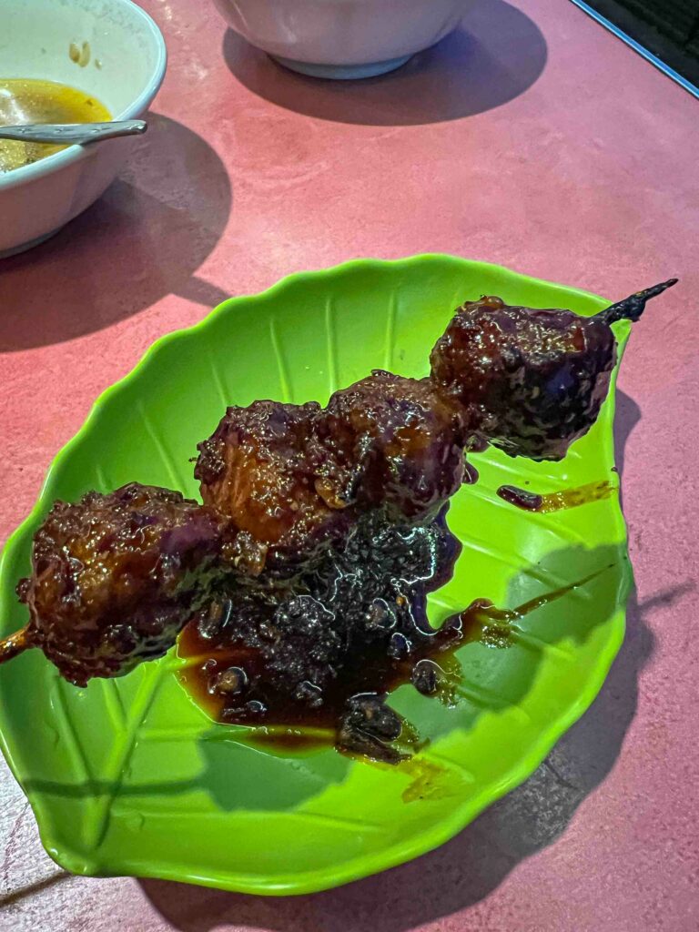 bakso bakar Indonesian grilled meatball in a spicy peanut sauce on a stick in Malang