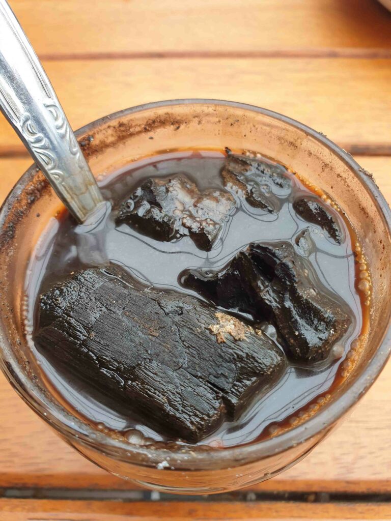 Famous yogakarta kopi joss charcoal coffee drink in a glass with a spoon