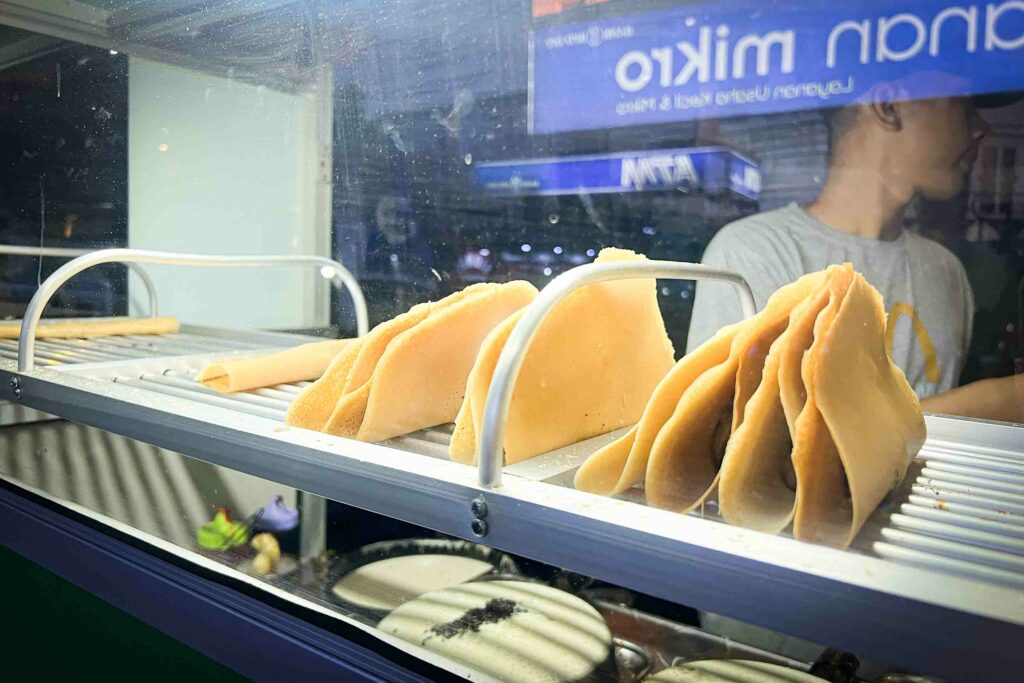 kue lekker Indonesian pancake at a street food market at night