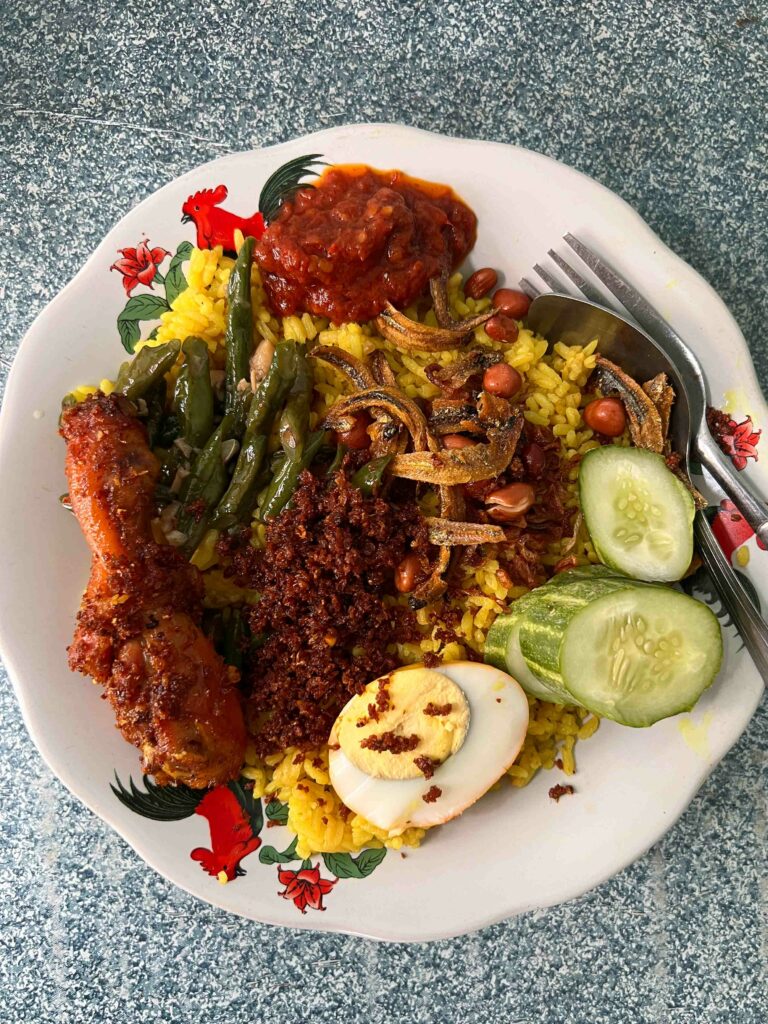 nasi kuning typical street food in Indonesia on a plate and a marble table
