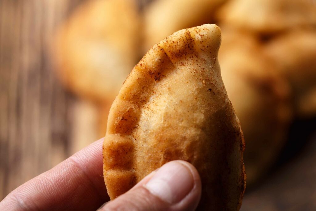 Man's hand holding Colombian empanada traditional Christmas food in Colombia