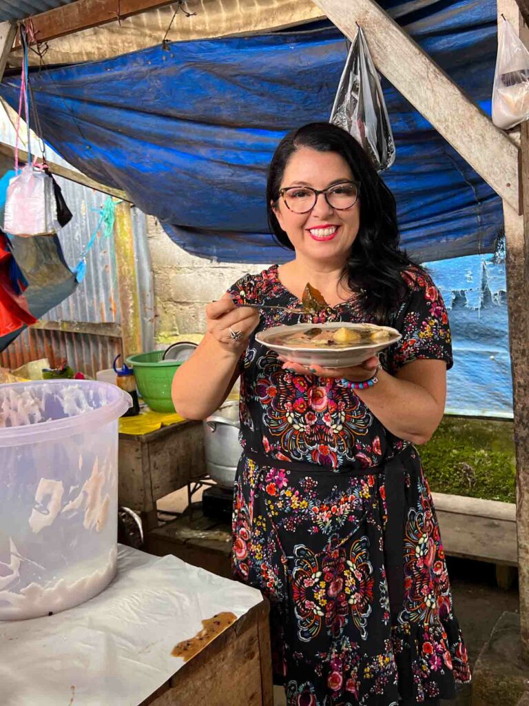 Ayngelina holding bubur kampiun sweet Indonesian rice porridge with sweet potato and coconut.