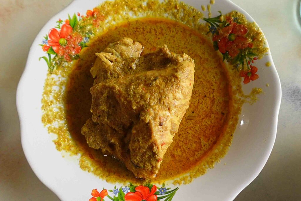 gulai ayam a chicken curry in a white bowl, a common Padang food in traditional restaurants