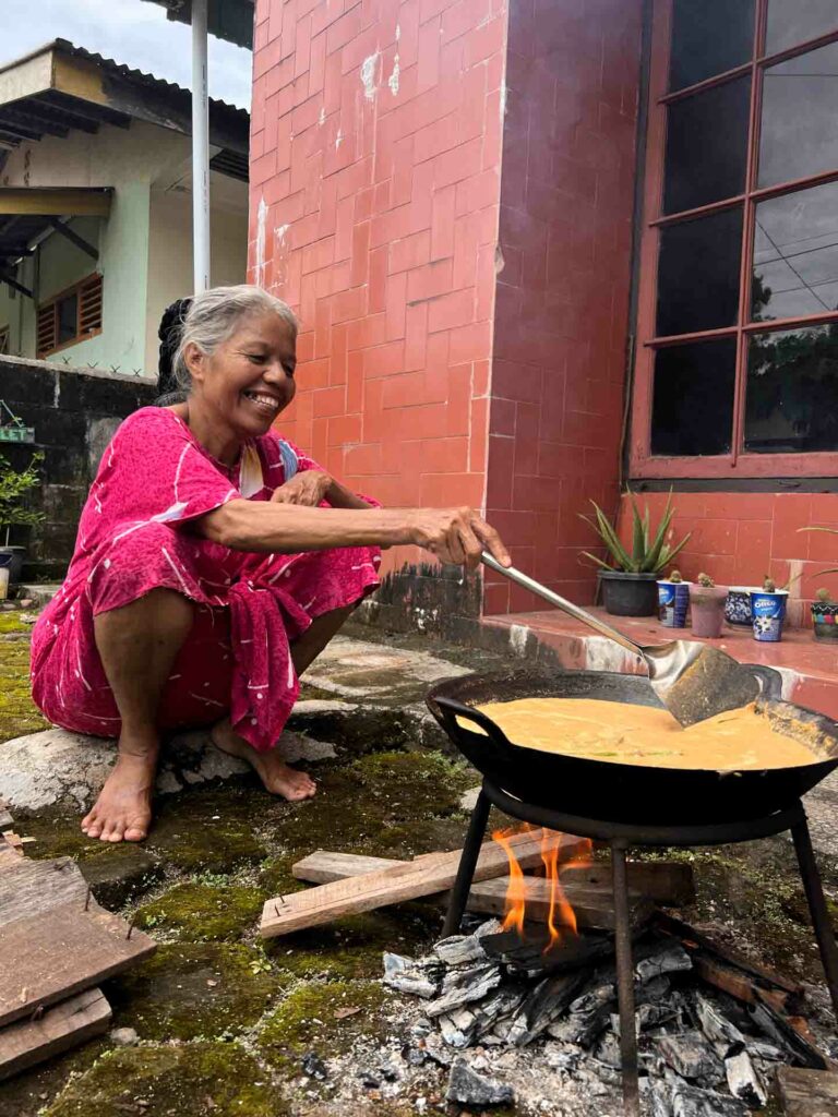 Woman cooking rendang, a typical Padang food traditionally cooked over fire