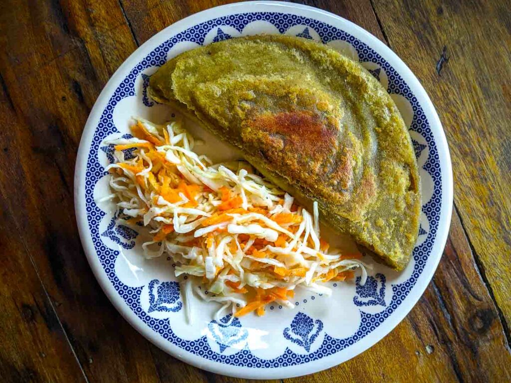 empanada verde ecuador breakfast on a plate with cabbage and carrot