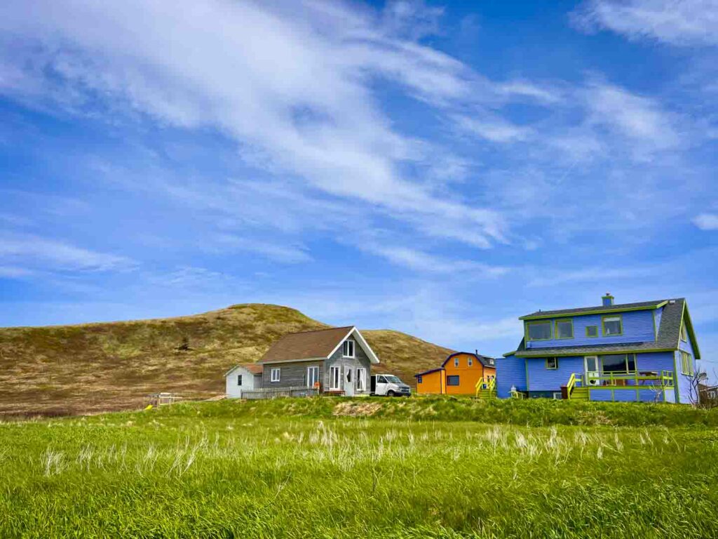 colorful houses in rolling green hills Magdalen Islands havre aux maisons