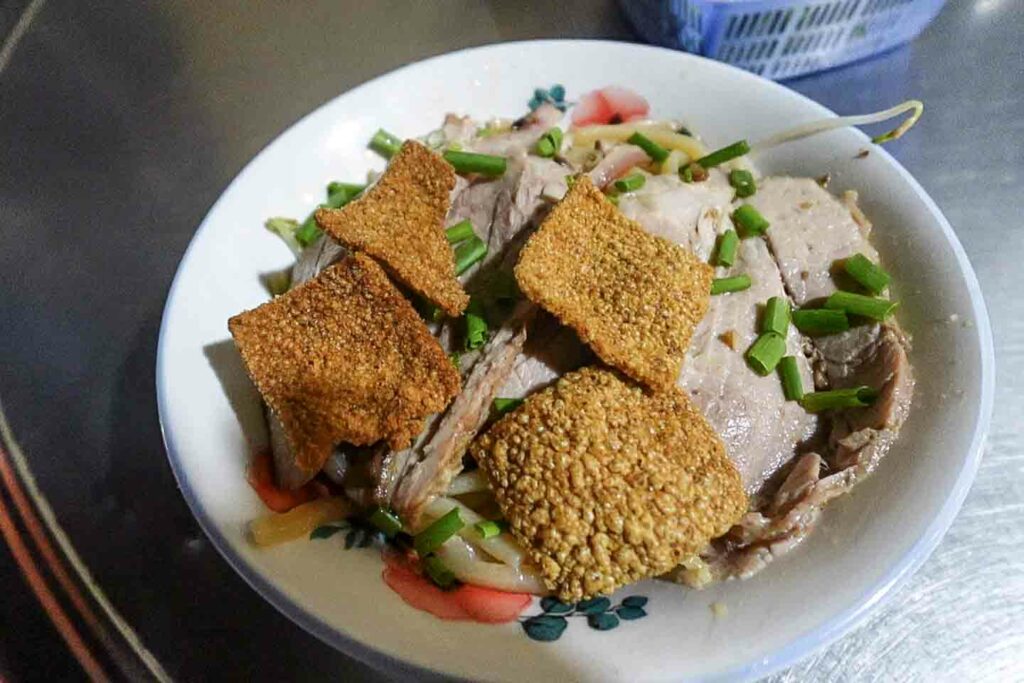 cao lau noodle dish in vietnam can only be made in Hoi An, typical dish with rice crackers and pork on top