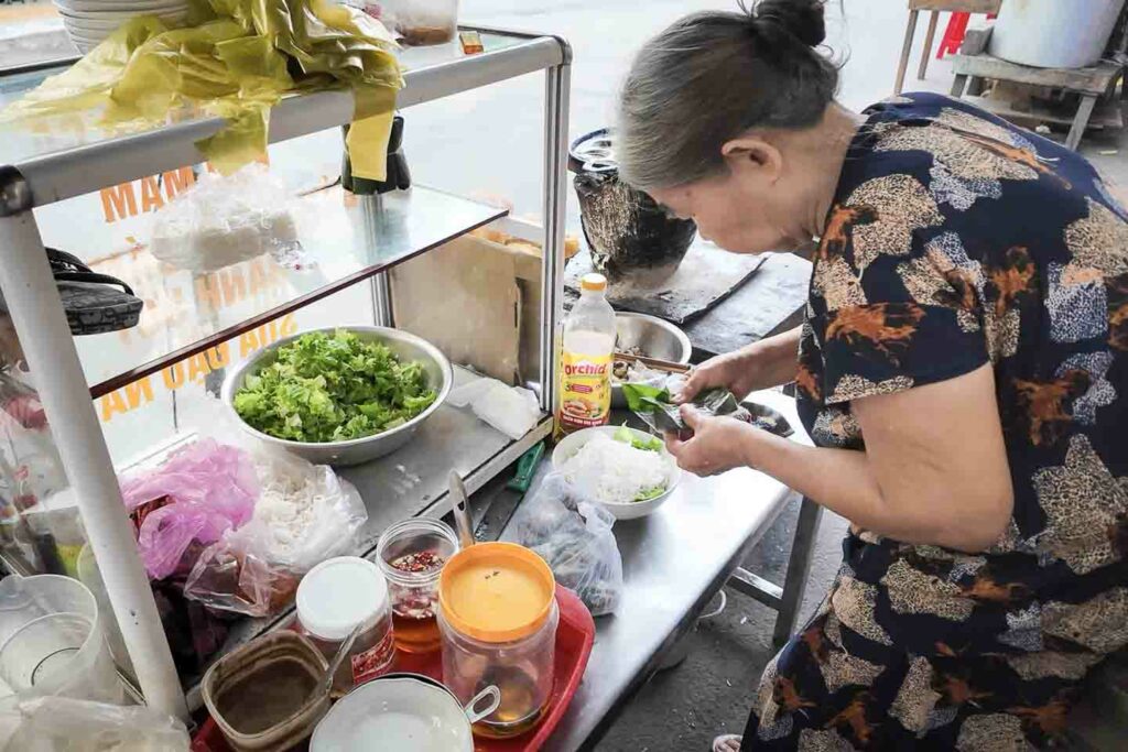 Vietnamese woman making bun mam nem, a specialty in Da Nang
