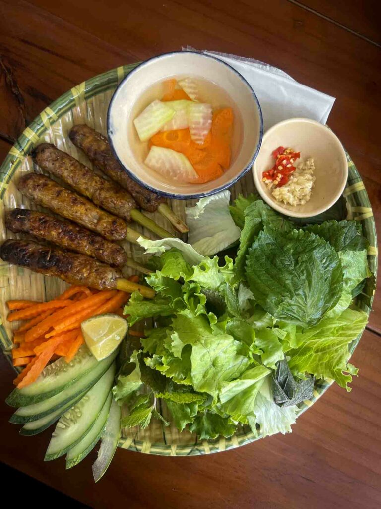 nem nướng Đà Nẵng a Vietnamese dish, grilled lemongrass skewers of seasoned pork. The pork is typically ground and molded onto lemongrass stalks, then grilled over charcoal. It's often served with rice paper, fresh vegetables, herbs,