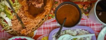 Mixiote de borrego, steamed lamb in agave membrane popular dish in Tlaxcala, on table with side dishes