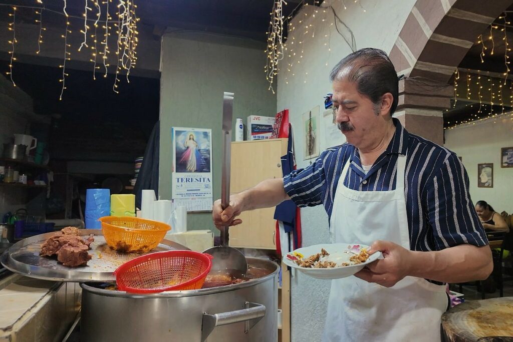 man serving Birria de chivo