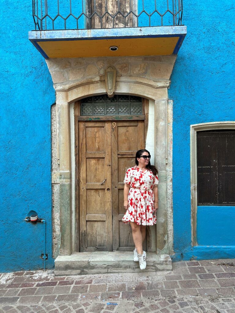 Ayngelina in Guanajuato in the doorway of a colorful blue house