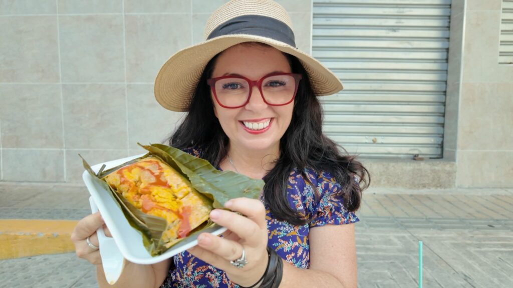Ayngelina with rice pastel tamal sitting on sidewalk in Santa Marta Colombia