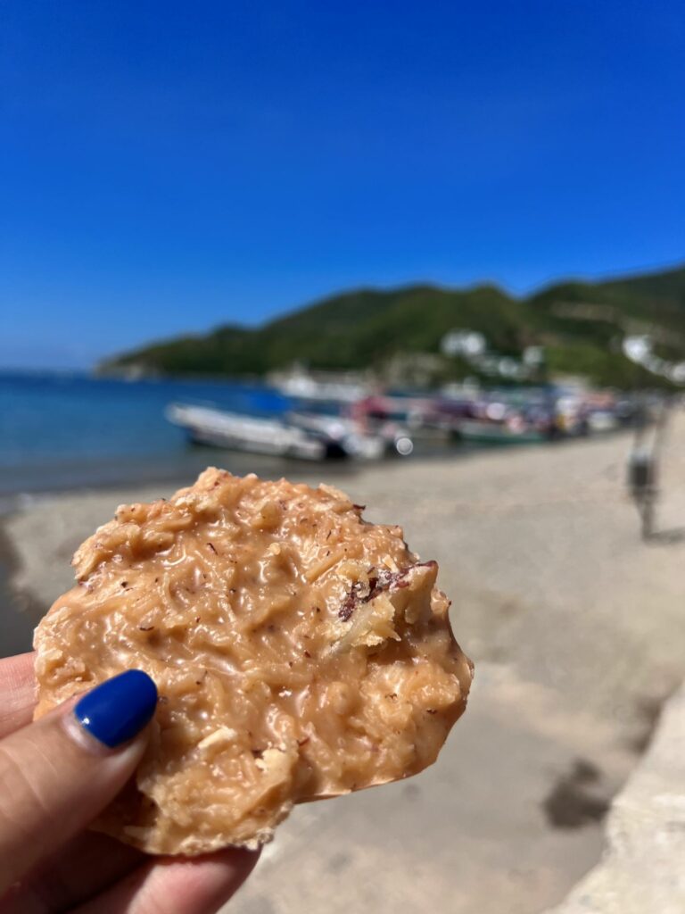 Colombian cocada in woman's hand at Taganga beach