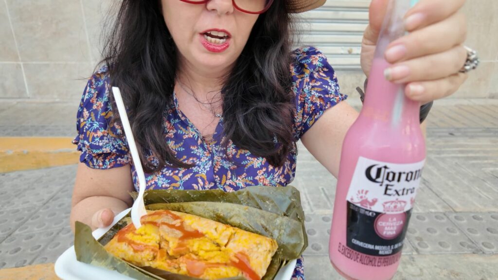 Ayngelina holding chicha, a pink homemade drink in a reused corona bottle on the streets in Santa Marta Colombia