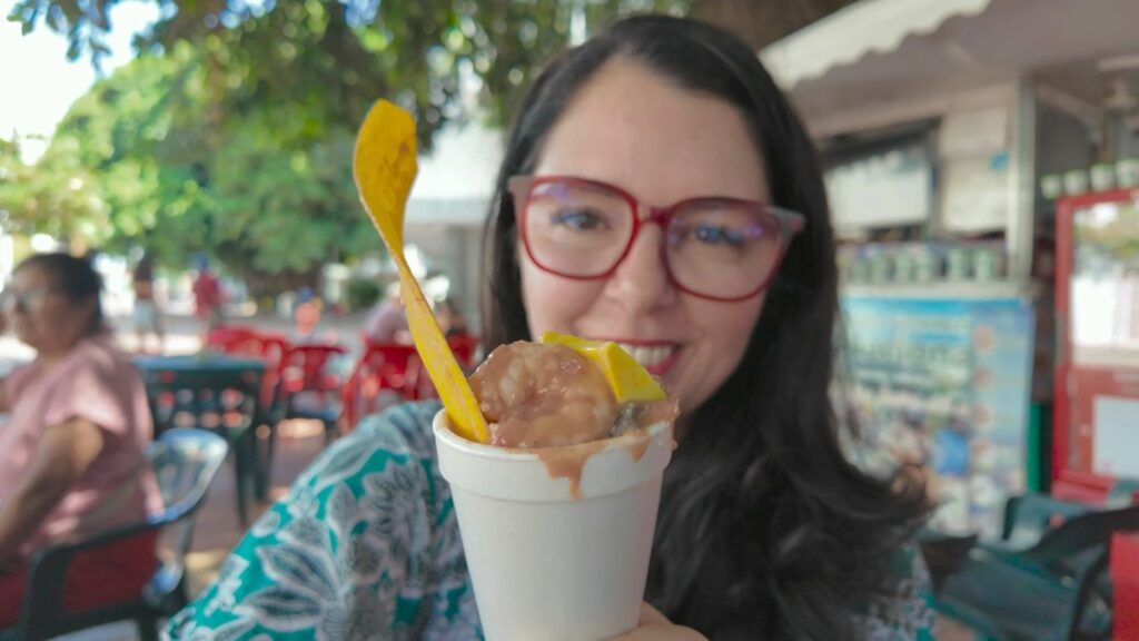 Ayngelina holding cup of La Bomba seafood cocktail in Cartagena