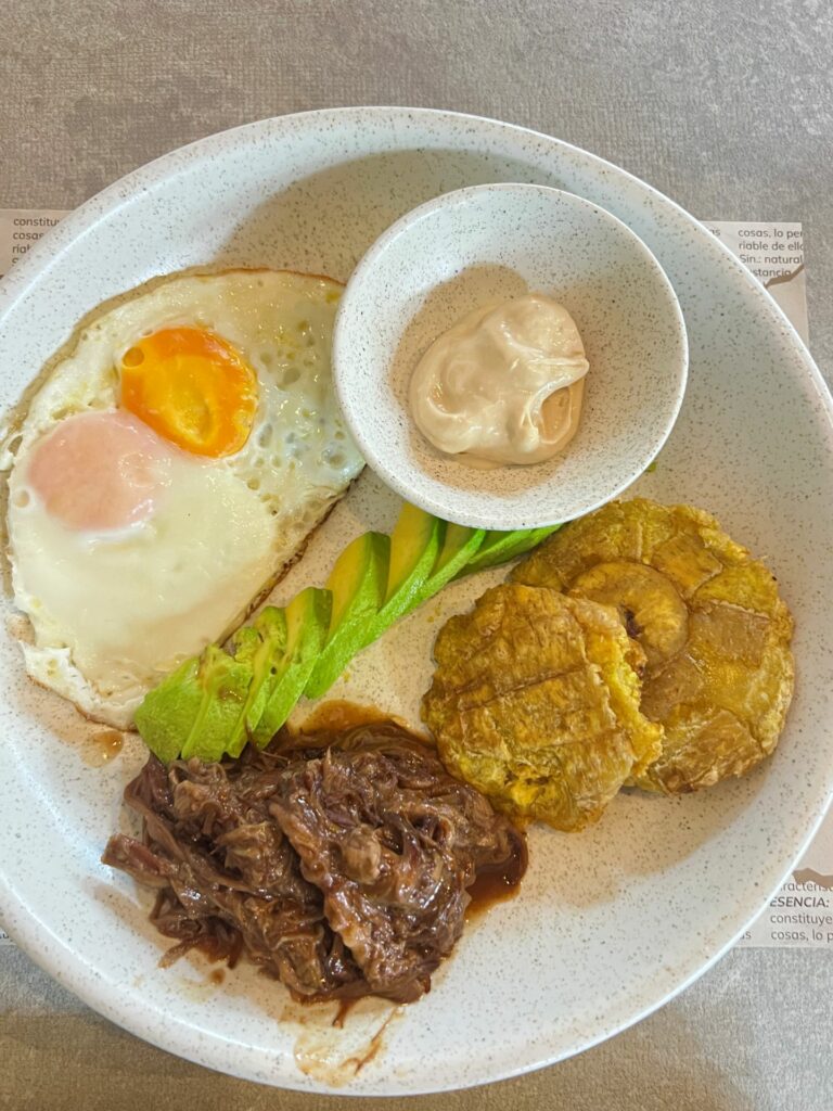 Colombian breakfast with posta negra beef, patacones, avocado, eggs and suero at a cafe in Cartagena