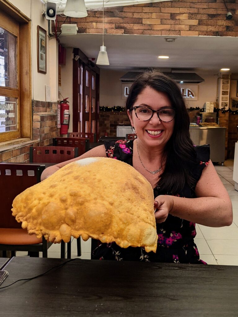 Ayngelina eating gigantic empanada in Quito Ecuador